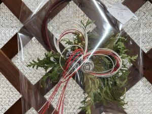 紅白の水引の付いたリースで正月飾り