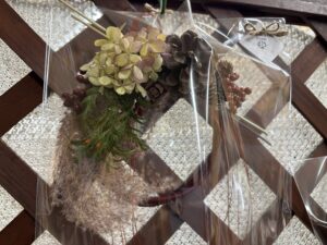 木の実やアジサイ、グラス系の植物をあしらえたリースにも水引を