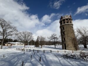 雪が積もった芝生広場とサイロの風景